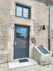 une porte sur un bâtiment en pierre avec une fenêtre et une boîte en pierre dans l'établissement Gîte l'Eden à l'Est, à Colombey-les-Deux-Églises