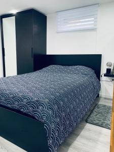 een slaapkamer met een bed met een blauw dekbed bij Le Buhlois, bienvenue en Alsace! in Buhl