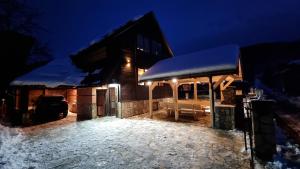 una casa di notte con neve sul tetto di Vila Bjelasica a Kolašin