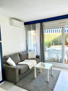 salon z kanapą i stołem w obiekcie A deux pas de la plage - Entre Nice/Cannes w mieście Villeneuve-Loubet +1 zdjęcie