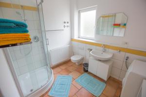 uma casa de banho com um chuveiro, um lavatório e um WC. em Apartment Yellow em Sigmarszell