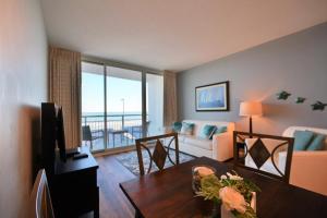 a living room with a table and a living room with a view at Spectacular Ocean Front Real 1 Bedroom Condo, 2 Ba in Myrtle Beach