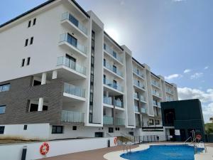 un edificio de apartamentos con piscina y parque infantil en Blue Sunset Luxury Seaview Apartment La Duquesa, en Manilva