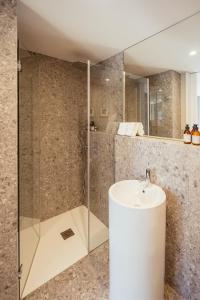 a bathroom with a sink and a glass shower at As Vizinhas Boutique Apartments in Porto