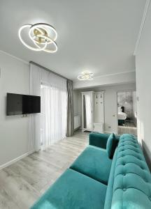 a living room with a blue couch and a tv at Glam Studios in Sibiu