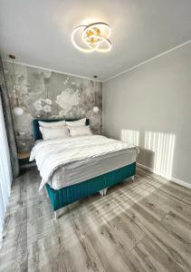 a bedroom with a large bed with a painting on the wall at Glam Studios in Sibiu