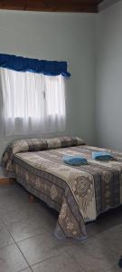 uma cama num quarto com uma janela em La casita em El Calafate