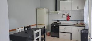 uma pequena cozinha com uma mesa e um frigorífico em La casita em El Calafate