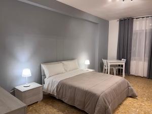 a bedroom with a bed and a table and a chair at Residenze Unità d'Italia in Bari