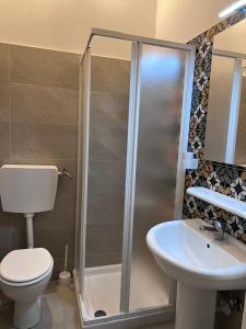 uma casa de banho com um chuveiro, um WC e um lavatório. em Residenze Unità d'Italia em Bari