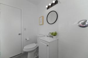 a white bathroom with a toilet and a mirror at Great Studio Residence 15 min from the beach in Miami