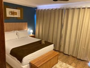 um quarto com uma cama grande e uma janela em Pousada Renovo da Serra em São Pedro da Serra