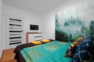a bedroom with a bed with a painting on the wall at Apartament Glamour Kraków in Krakow