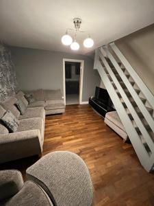 sala de estar con sofá y escalera en 2 bed semi-detached house en Warrington