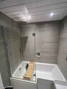 La salle de bains est pourvue d'une baignoire et d'une douche en verre. dans l'établissement 2 bed semi-detached house, à Warrington