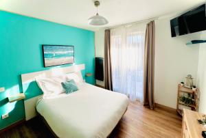 Dormitorio azul con cama y pared azul en Studio avec piscine aux portes d’Honfleur en Honfleur
