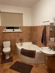 a bathroom with a tub and a toilet and a sink at Studio apartamenti Cēsis in Cēsis +4 photos