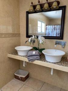a bathroom with two sinks and a mirror at Villa Del Carmen Family Vacation Home in Isabela