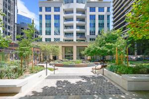 a courtyard with benches and trees in a city at The Alexander Apartments - Harbour Views, Parking, Pool, 24hr Concierge in Sydney