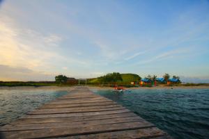 a wooden dock in the water on a beach at PASERANG PARIRI PARADISE in Labuberu