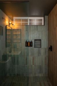 a bathroom with a shower with a sink and bottles at Hotel Marina Riviera in Big Bear Lake