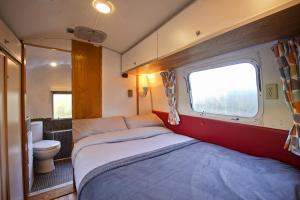 um pequeno quarto com uma cama e um WC em The Airstream em Penryn