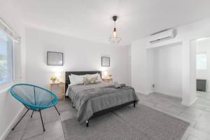 1 dormitorio con 1 cama y 1 silla azul en Beautiful Studio 15 min from the beach, en Miami