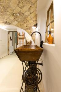Habitación con baño con lavabo de madera. en Crobi Museum and Suites, en Cagliari