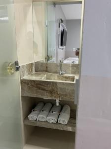 a bathroom with a sink and a mirror and towels at TERESINA HOTEL in Teresina