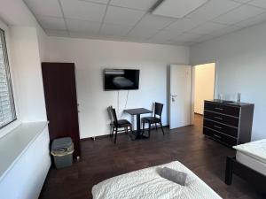 Apartmenthaus في لينغن: غرفة نوم بسرير وطاولة وكراسي