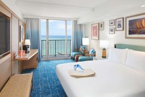 a hotel room with a bed and a view of the ocean at OUTRIGGER Reef Waikiki Beach Resort in Honolulu