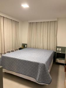 a bedroom with a large bed in front of curtains at Casa Califórnia in Itacimirim