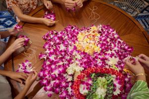 ホノルルにあるOUTRIGGER Reef Waikiki Beach Resortの花の飾りを作る人々