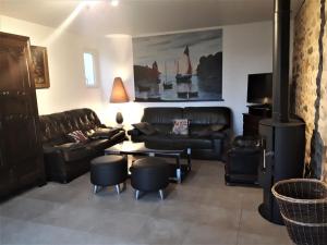 a living room with leather couches and a table and chairs at Menhir in Hôpital-Camfrout