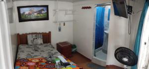 a small bedroom with a bed and a shower at HOTEL NUEVO GALEX in Acacías