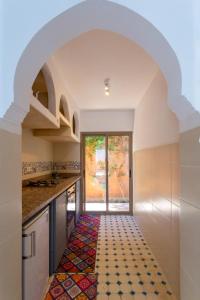 a kitchen with an archway and a colorful tile floor at Villa Paradis in Marrakesh