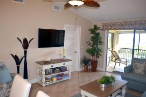 a living room with a couch and a tv at SANDPIPER BEACH 205 in Sanibel
