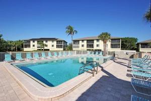 a large swimming pool with chairs and a resort at SANDPIPER BEACH 205 in Sanibel