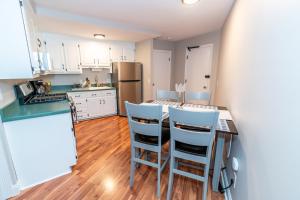 a kitchen with white cabinets and a table and chairs at Beautiful Space all for you! in New Britain