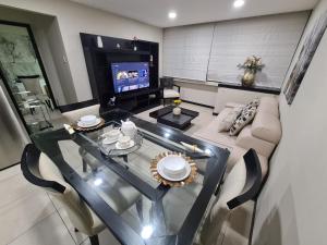 a living room with a glass table and a couch at Ecusuites Room Emporium con Jacuzzi privado in Guayaquil