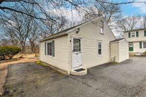 a small white building with a door in a driveway at Charming Warwick Vacation Rental Walk to Bay in Warwick