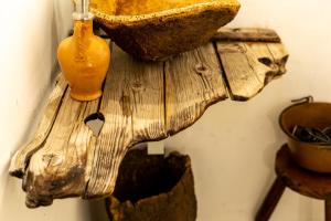 a wooden cross hanging on a wall with a vase at Crobi Museum and Suites in Cagliari