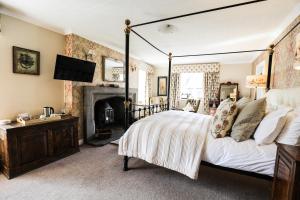 a bedroom with a large bed and a fireplace at The Black Swan in Ravenstonedale