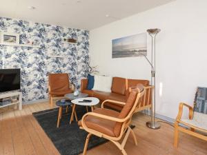 sala de estar con sofá, sillas y TV en Holiday home Bindslev VI, en Bindslev