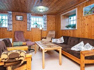 6 person holiday home in Ribe في ريبي: غرفة معيشة مع أريكة وطاولات ونوافذ
