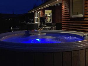 - un grand bain à remous bleu dans un jardin la nuit dans l'établissement 10 person holiday home in Juelsminde, à Juelsminde