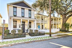a yellow house with a white fence on a street at Chic Thomas Square Home in Walkable Location! in Savannah