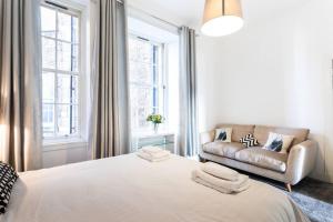 格拉斯哥GLASGOW WEST END 5 MIN WALK TO SECC AND HYDRO的白色卧室设有一张大床和一张沙发