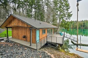 a cabin on a lake with a dock at Dreamy Bayfront Cabin with View, Dock and Kayaks in Olympia