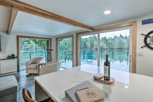 a living room with a table with a bottle of wine at Dreamy Bayfront Cabin with View, Dock and Kayaks in Olympia